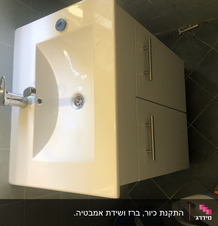 כיור עם ברז וכיור ארון בחדר אמבטיה